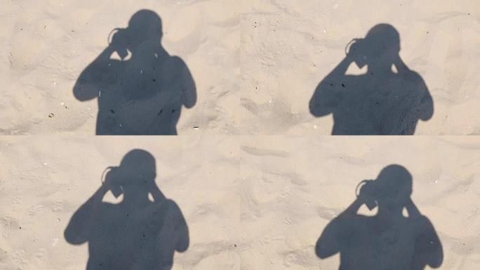 男人走在沙滩上，脱下他的影子