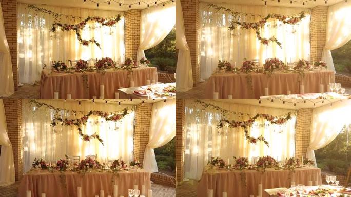婚礼桌乡村风格的装饰，配有粉色和米色的菜肴、饮料和鲜花。派对宴会餐桌上玫瑰的植物组合