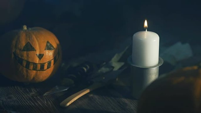 万圣节南瓜头灯笼，黑底燃烧蜡烛，木桌上有刀和勺子。庆祝万圣节的节日，庆祝