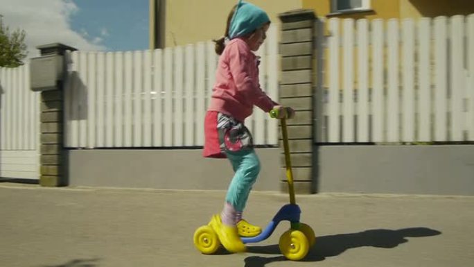 可爱的年轻女孩练习滑板车