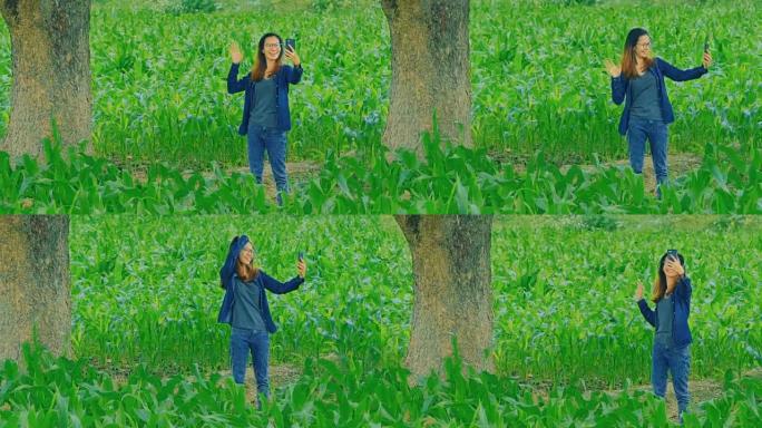 在玉米地里用智能手机进行视频通话的亚洲年轻女子