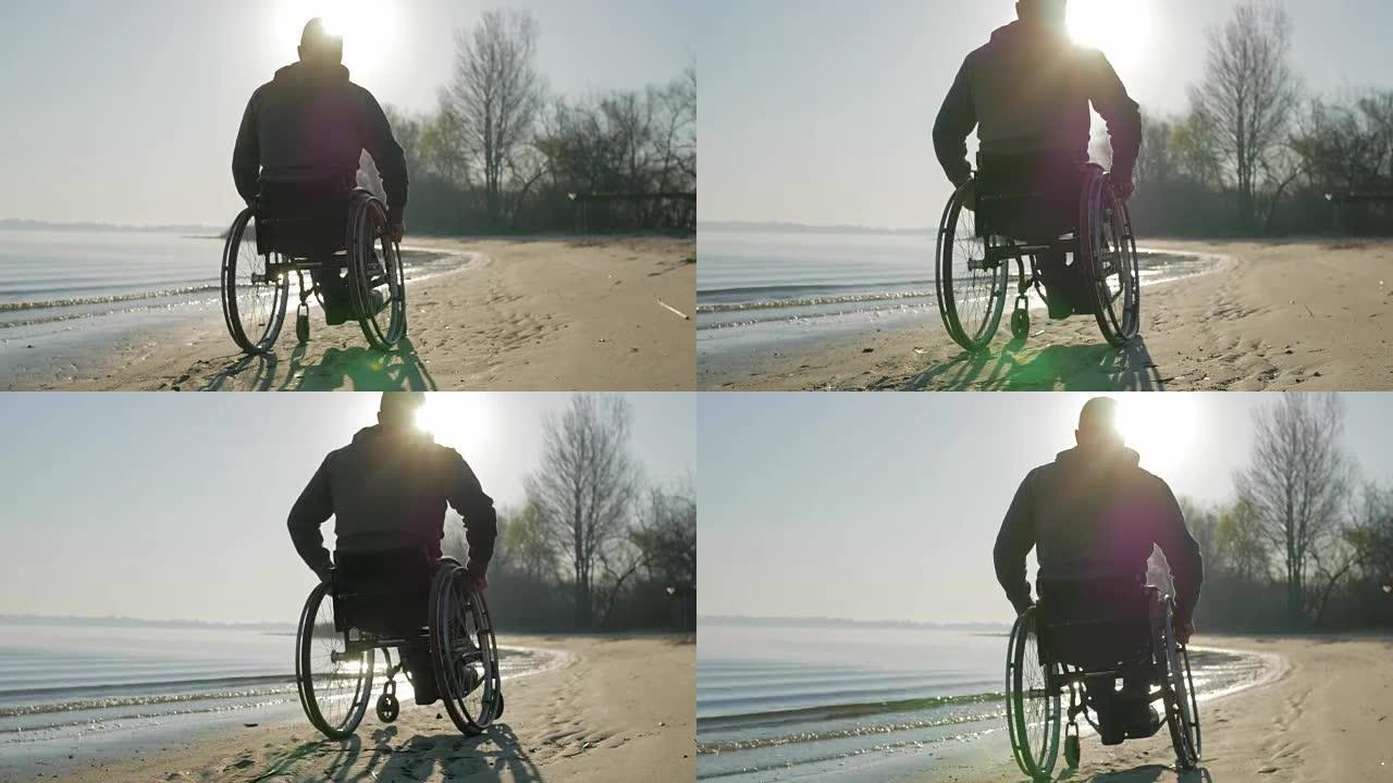 坐在轮椅上的残疾人沿着海滩推着自己