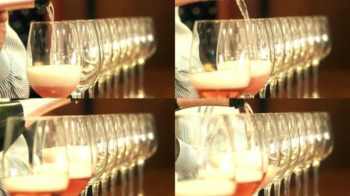 侍酒师将玫瑰酒倒入一排水晶玻璃杯中