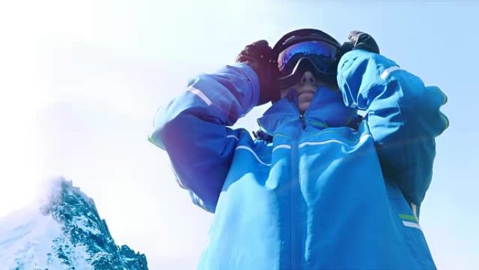 女滑雪者将眼镜放在蓝天上的低角度视图