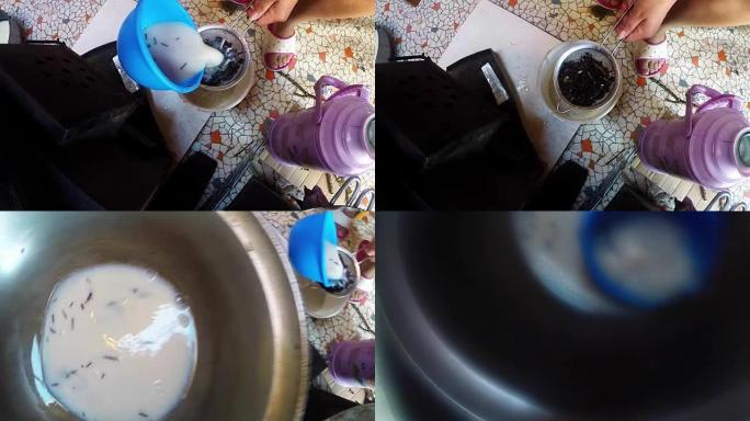 女人用手倒奶茶，透过过滤网俯视家居用品
