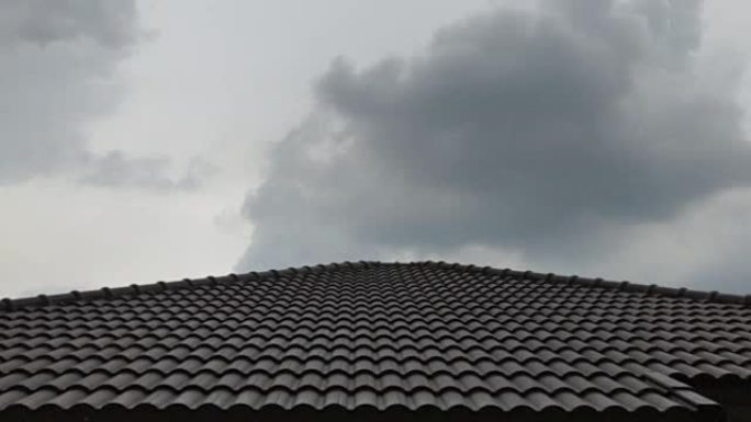 在屋顶房屋模糊的大雨之前，乌云的时间流逝