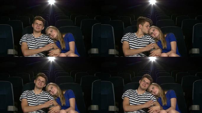 伟大的电影!年轻夫妇在电影院互相喂食