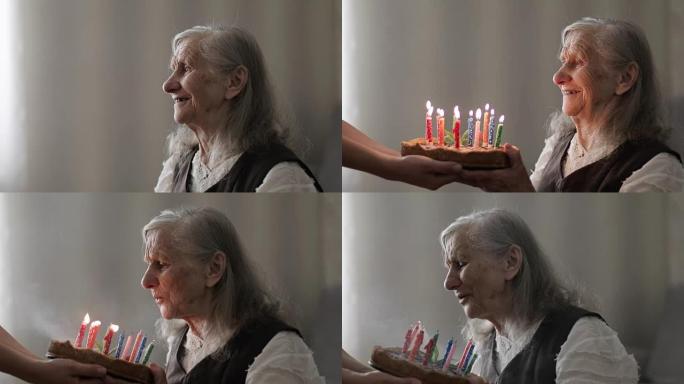 满头白发的快乐老妇人在蛋糕上吹蜡烛。