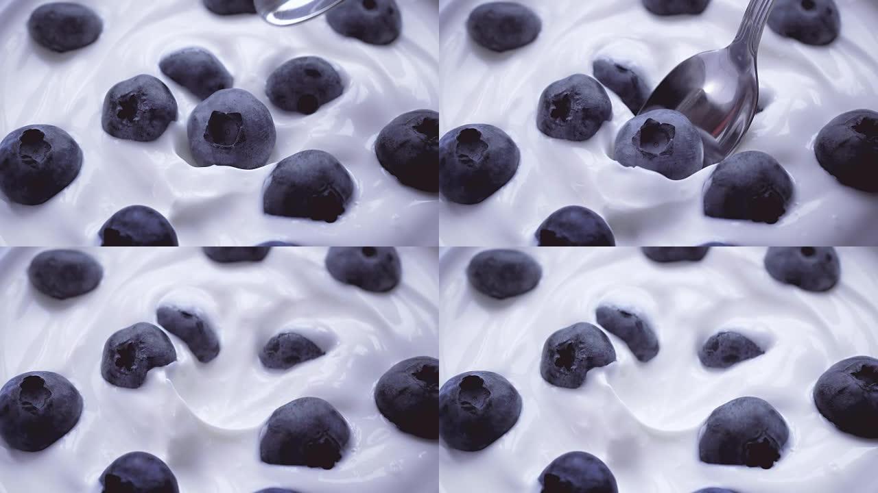 用勺子吃奶油蓝莓，水果背景。4k。