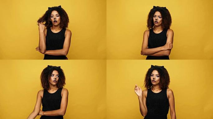 年轻的非洲妇女不满意，猫的化妆和耳朵没有显示出黄色孤立的手势
