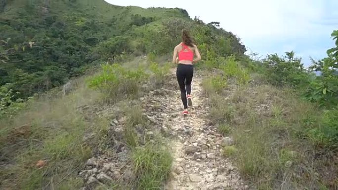 年轻的运动男孩和女孩在山路上慢跑。女人和男人在大自然中锻炼。慢动作