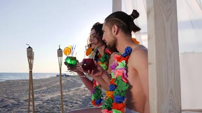 快乐的朋友在海洋海岸喝鸡尾酒，美丽的夫妇从夏威夷的脖子上到夏威夷群岛
