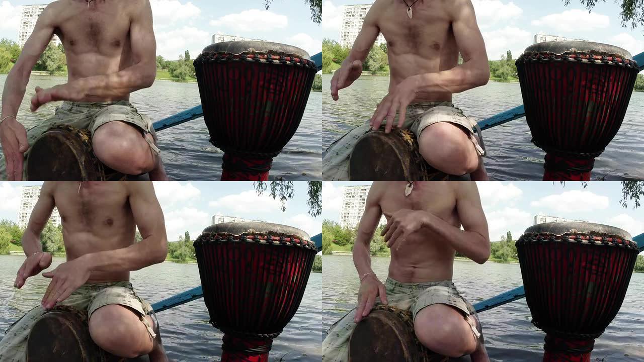 鼓手的手在湖泊和建筑物的背景下在临时鼓上演奏