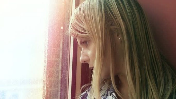 绝望的年轻女子迷失了自己的想法: 悲伤的女人看着窗外