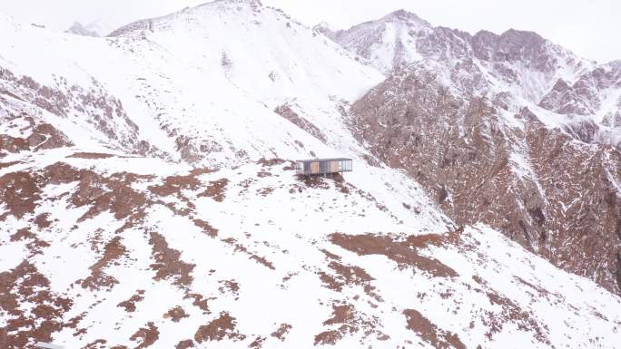 4k航拍雪山上的房子