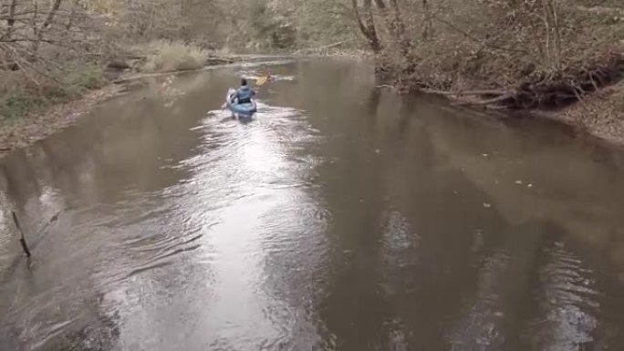男子在森林河上划独木舟