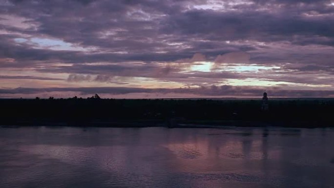河上的日出和背景中河边望塔上的多云天空