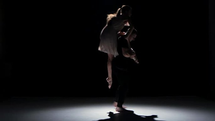 男人和女人开始在black，shadow上表演当代舞蹈