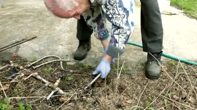 资深老人在花园中铺设水管