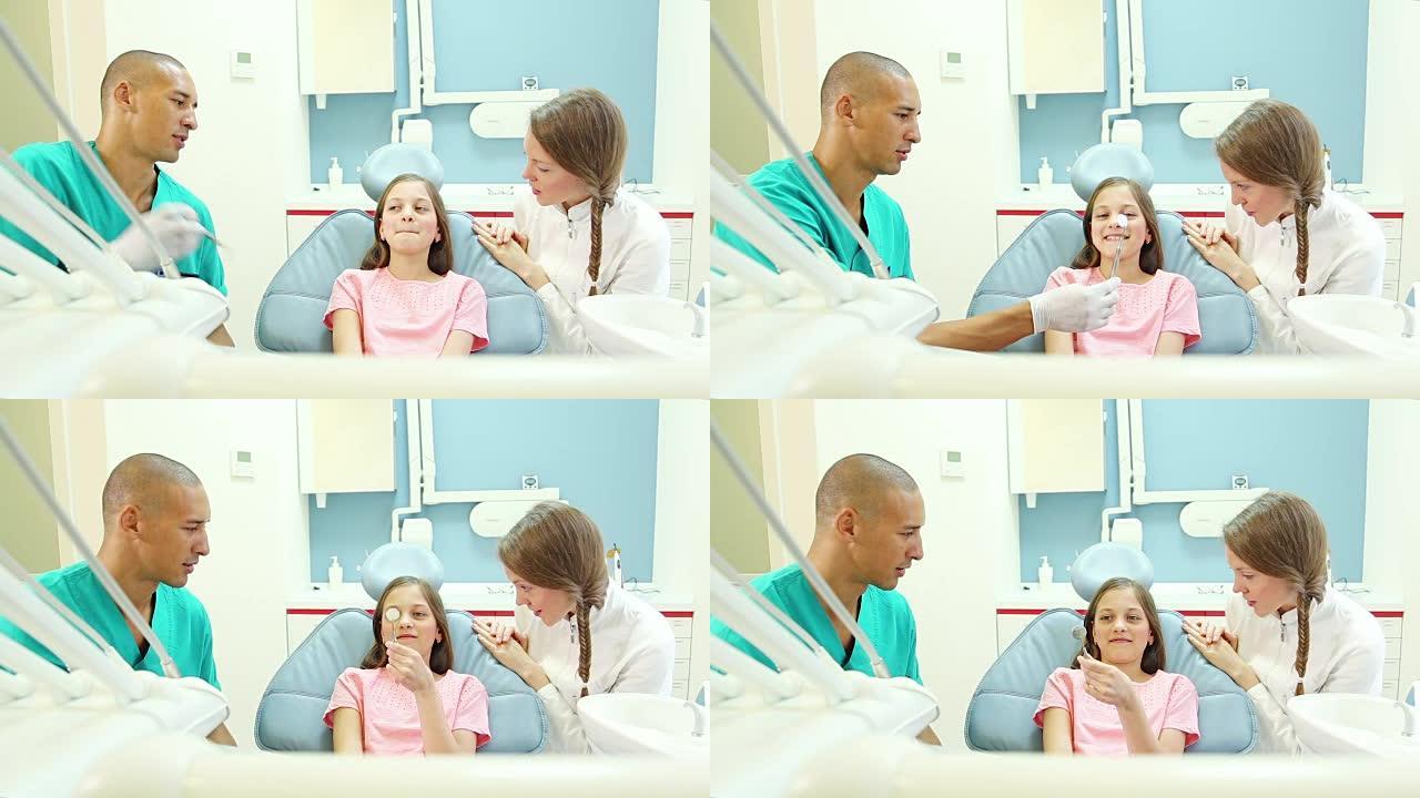 友好的牙科医生和牙医向可爱的小女孩展示口腔镜