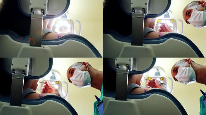 牙科医生打开灯并检查患者的低角度特写