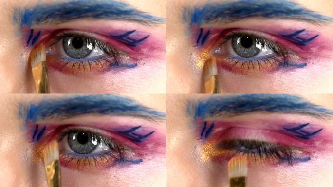 眼底化妆女人涂抹眼影，制作异国情调，一个，蓝色眉毛，黄色阴影，特殊刷子，点睛，特写，白色，慢动作