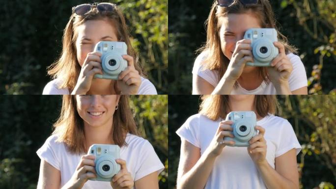 年轻的时髦女人拿着retor insta相机拍照