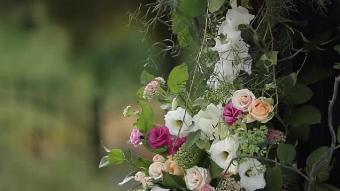 户外婚礼的婚礼装饰品。用白色和粉红色玫瑰装饰的木制拱门。蜜蜂和大黄蜂在天然花朵周围飞翔