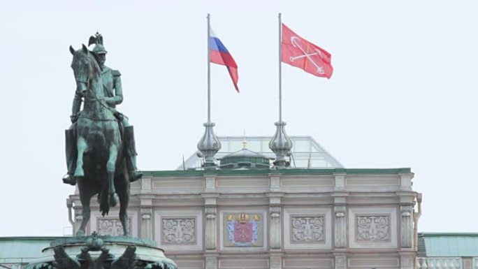 纪念碑的背景上有俄罗斯国旗和圣彼得堡国旗