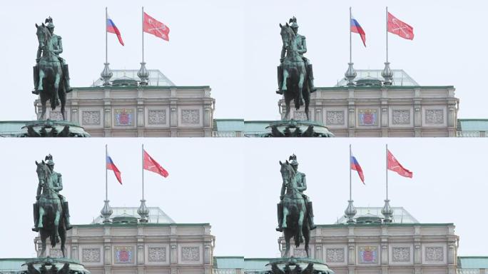 纪念碑的背景上有俄罗斯国旗和圣彼得堡国旗