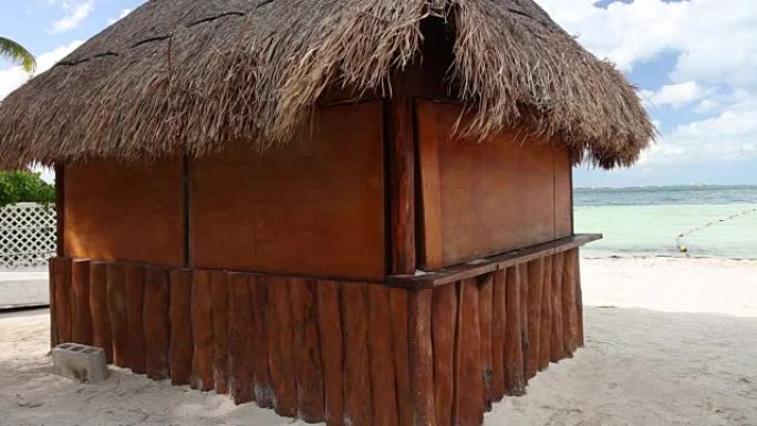 海岸上有棕榈叶屋顶的热带木屋