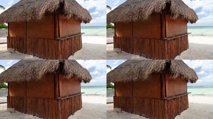 海岸上有棕榈叶屋顶的热带木屋