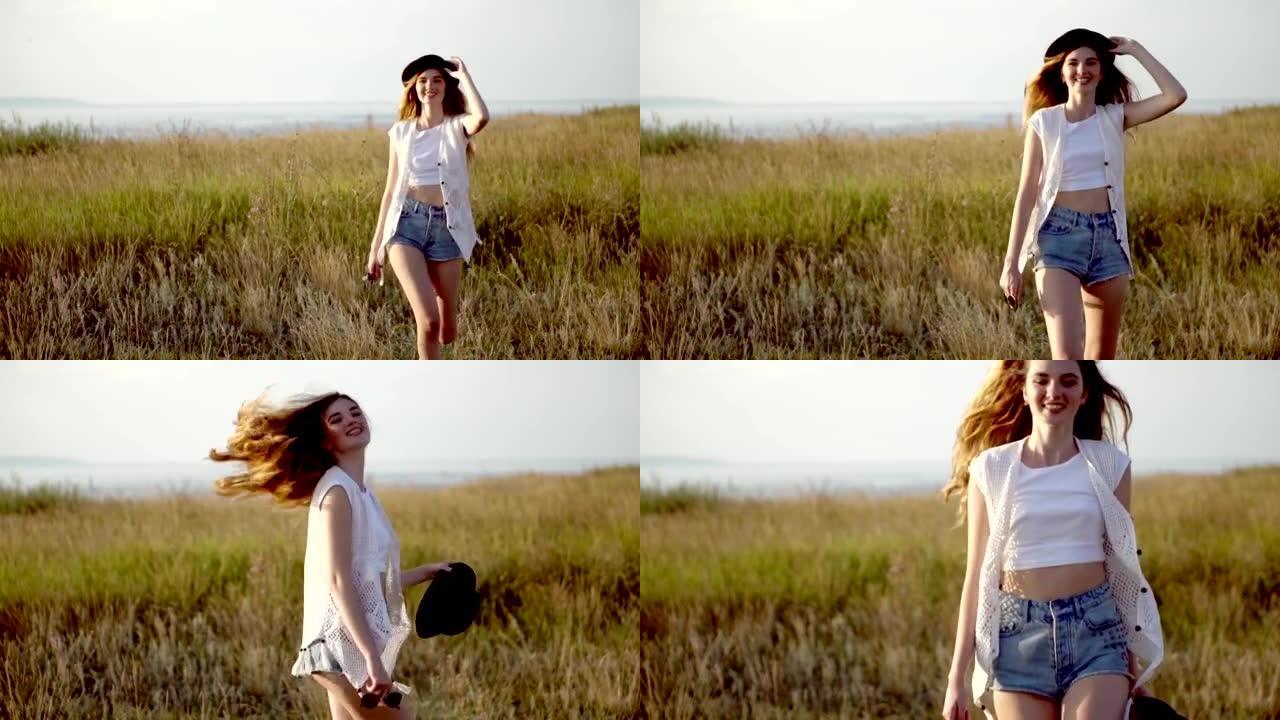 年轻漂亮的女孩模特戴着帽子，在河边的草地上跳舞