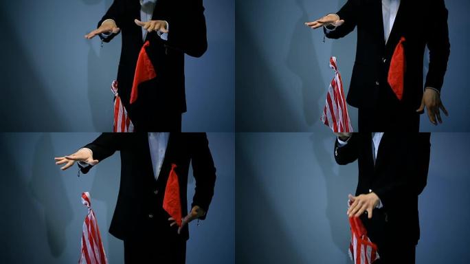魔术师在黑色背景上展示飞行红色餐巾的技巧。