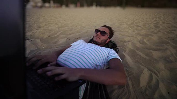 海滩上的Man笔记本电脑-4k分辨率