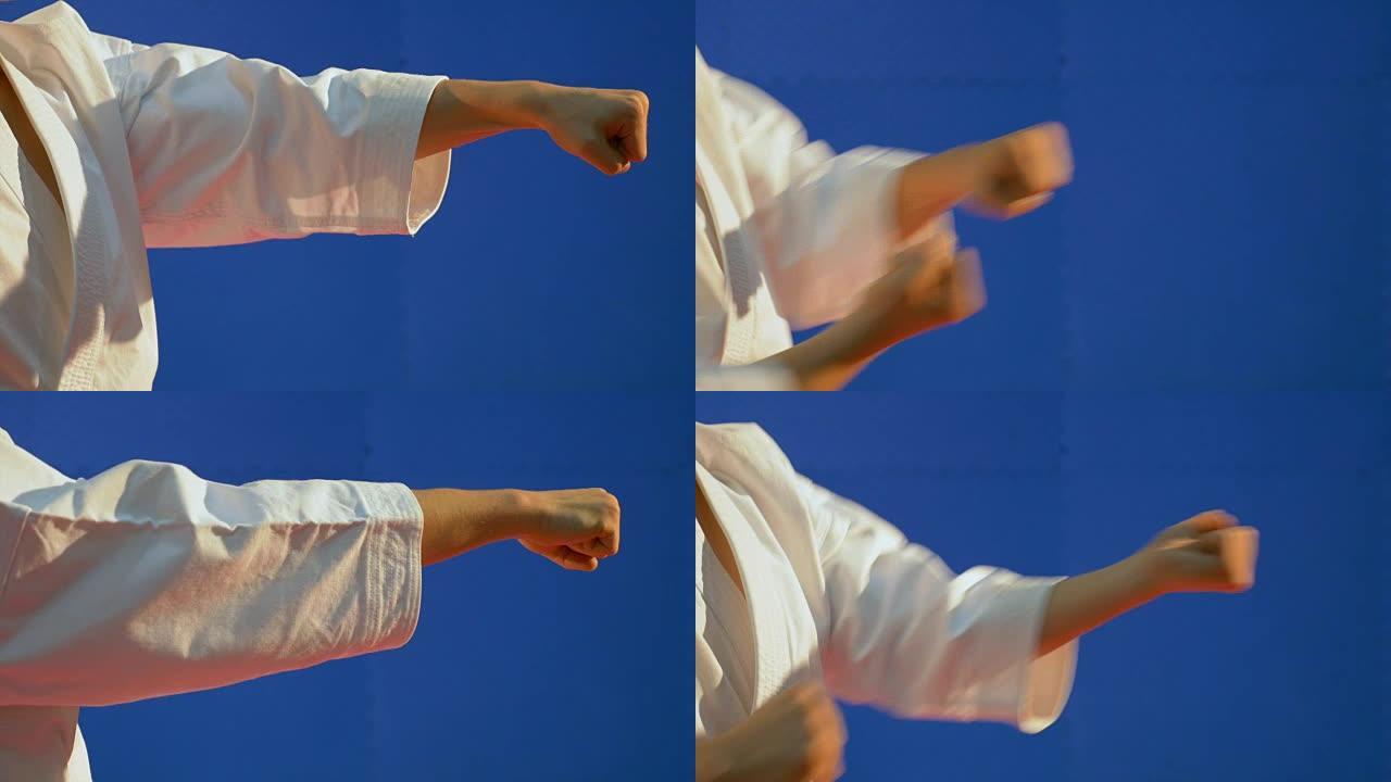 穿着和服的男子的拳头慢慢挥拳以显示空手道技术