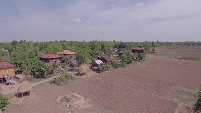 在传统的东南亚木制高跷房屋前，用红瓦屋顶向后飞过高跷。