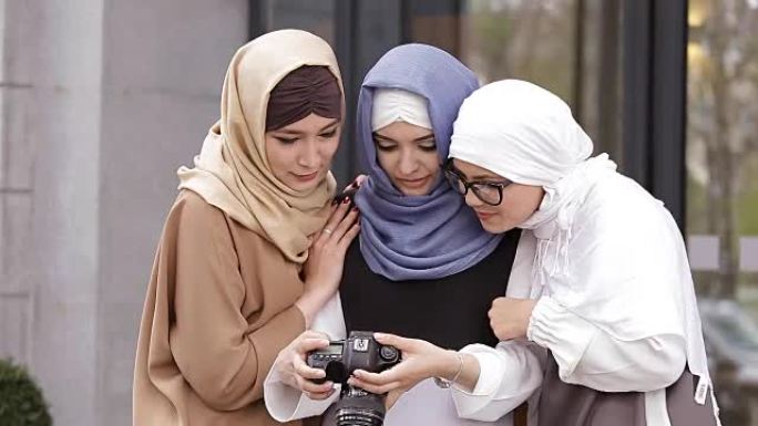 年轻的穆斯林女孩看照片
