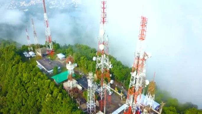 城市上空山上有雾的电信桅杆电视天线的鸟瞰图