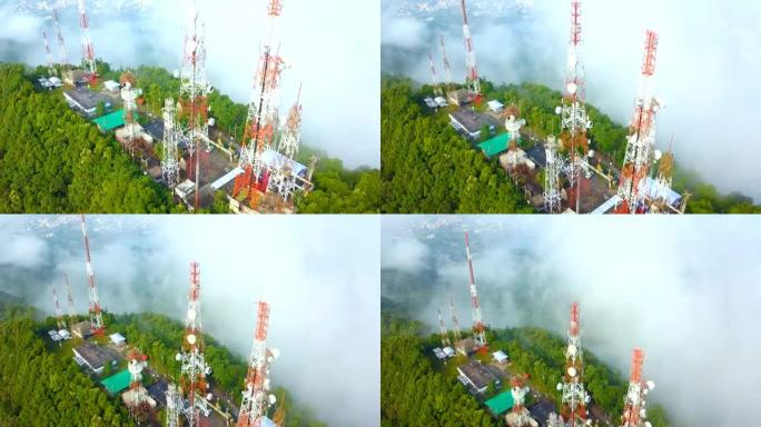 城市上空山上有雾的电信桅杆电视天线的鸟瞰图