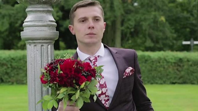 一个紧张的新郎，手里拿着一束鲜花在等他的新娘。慢动作。