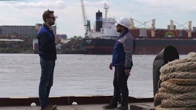 两个好朋友，码头工人和同事在货运港口击掌并说再见