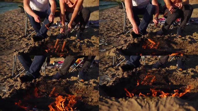 近距离拍摄人们的手和身体，他们在火刑柱上煮肉香肠