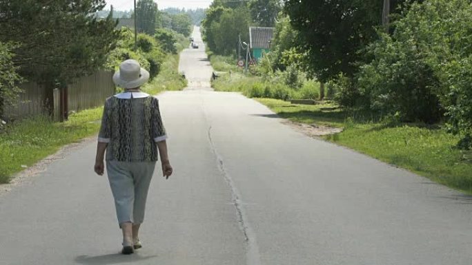 老妇走在村里的路上