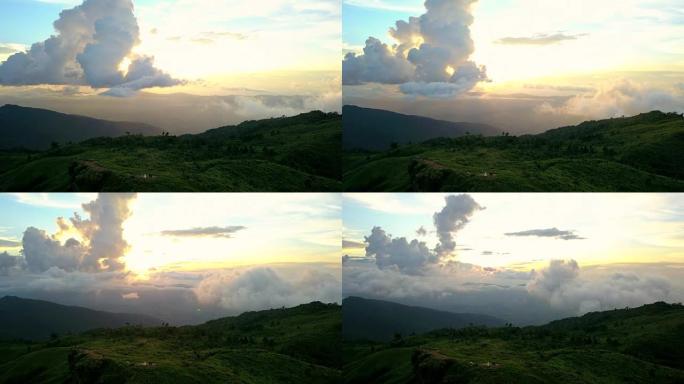 在泰国Chaingrai省的Phu Chi Fa，太阳落在山上蓬松的云的运动后面，黄色的暮光天空