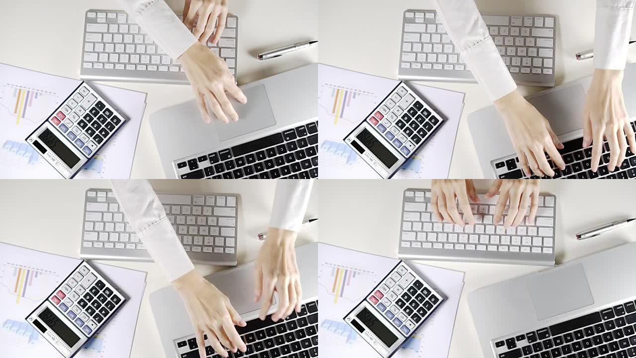 在办公室工作并在白色办公桌上打字的女商人在计算机和笔记本电脑上打字