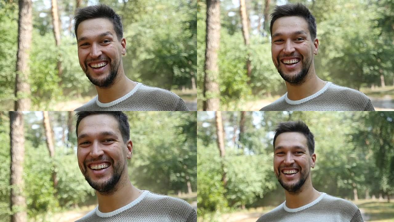 一个快乐的大胡子男人在夏天的松树林中以慢动作微笑