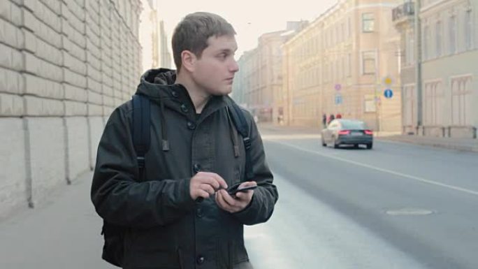 年轻人拿着手机在大城市的街道上寻找正确的道路