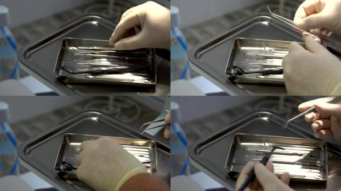 戴手套的牙医手从托盘上拿一个小镜子和镊子作为工具