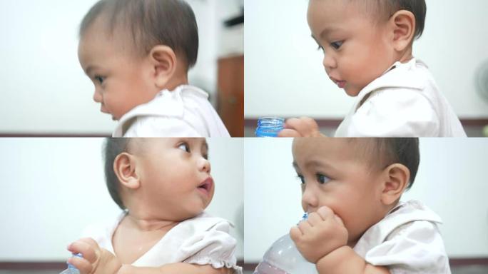 婴儿尝试从瓶子里喝水